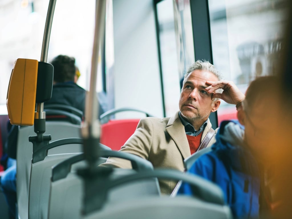 Trabajador viajando en bus en la ciudad, reflejando el impacto del alza del combustible en su traslado diario al trabajo en Chile.